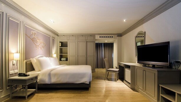 A hotel room with a bed, bedside table, lamp, TV, and built-in cabinets. - imm hotel Ladprao Bangkapi Bangkok (Bangkok)