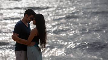 Una pareja abrazándose junto al agua.