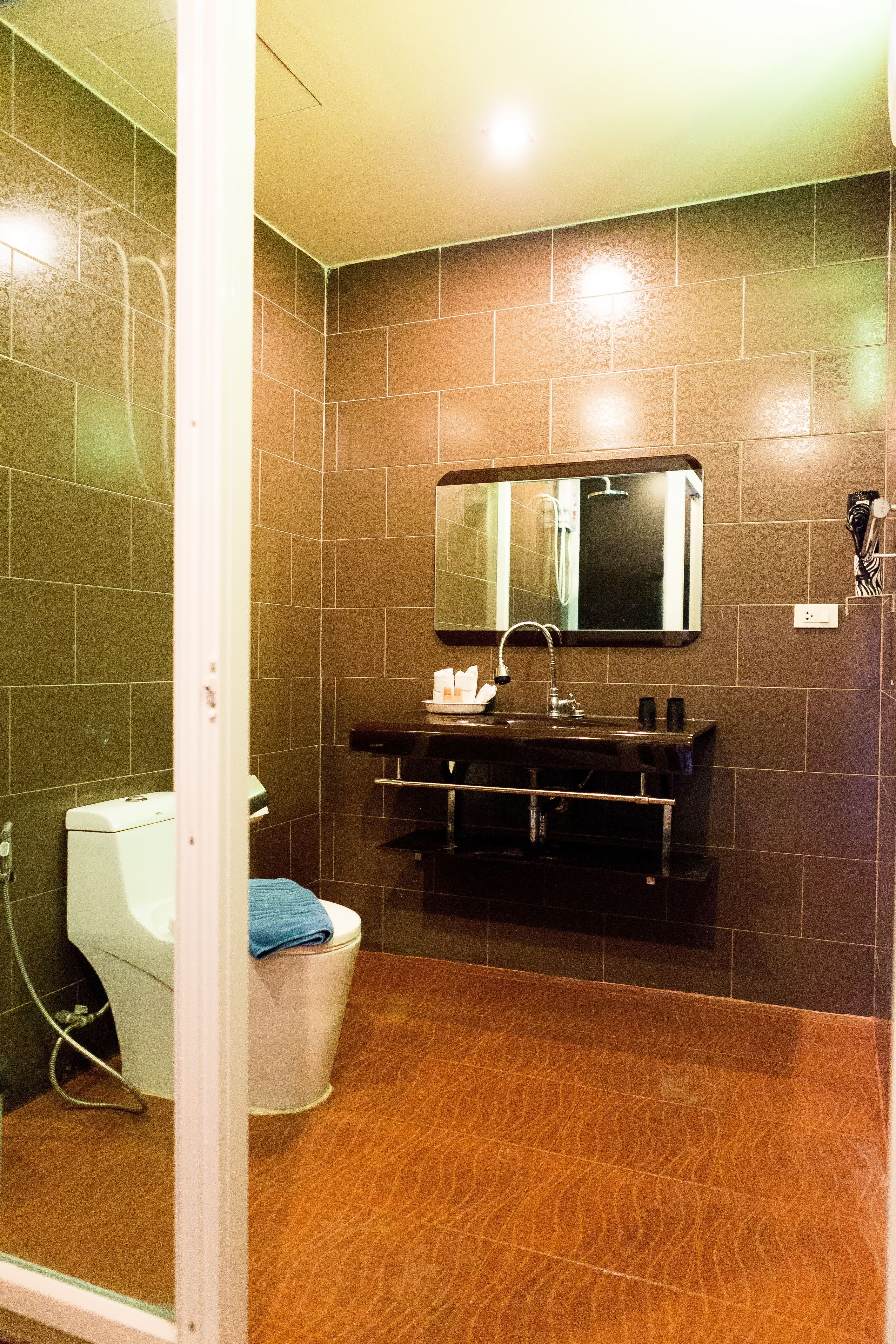 Een badkamer met toilet, wastafel en spiegel.
