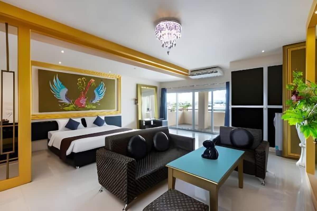 A hotel room with a bed, sofa, table, and a large window.