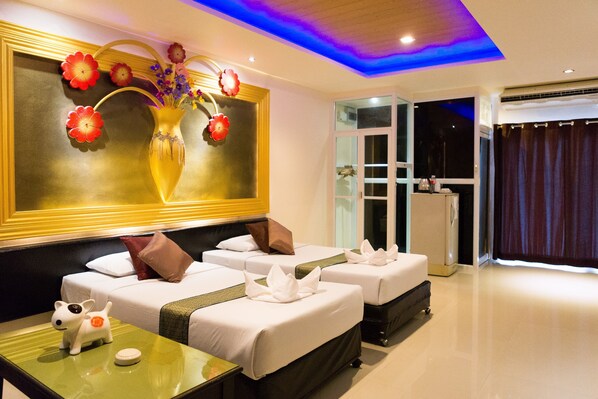 Quarto de hotel com duas camas, um quadro floral grande na parede e vista para o exterior.
