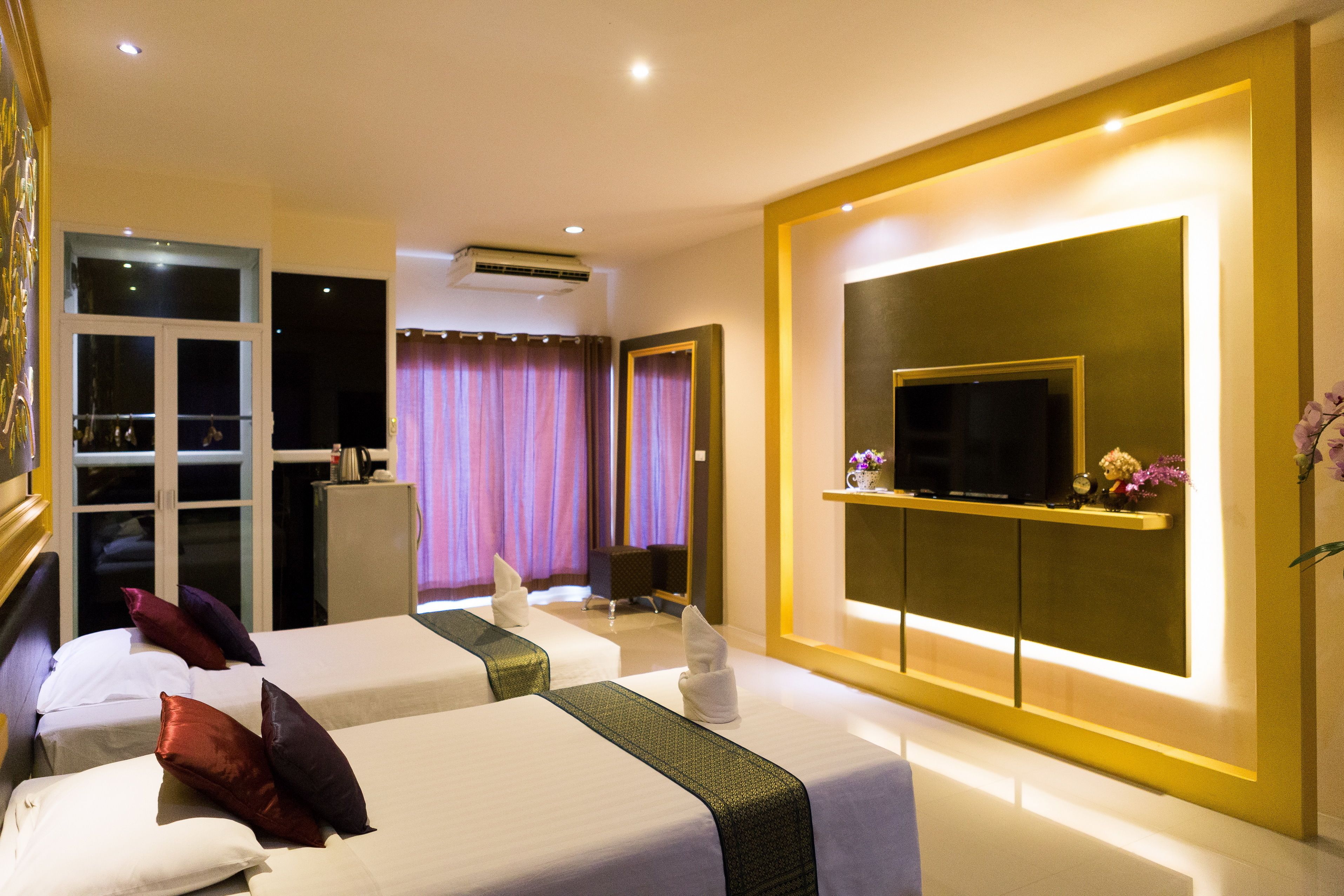 Une chambre d’hôtel avec deux lits, une télévision et un mini-bar.
