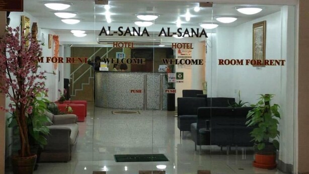 The entrance of Al-Sana Hotel with a reception desk, seating area, and clear signage for room rental. - Al-Sana Hotel (Bangkok)
