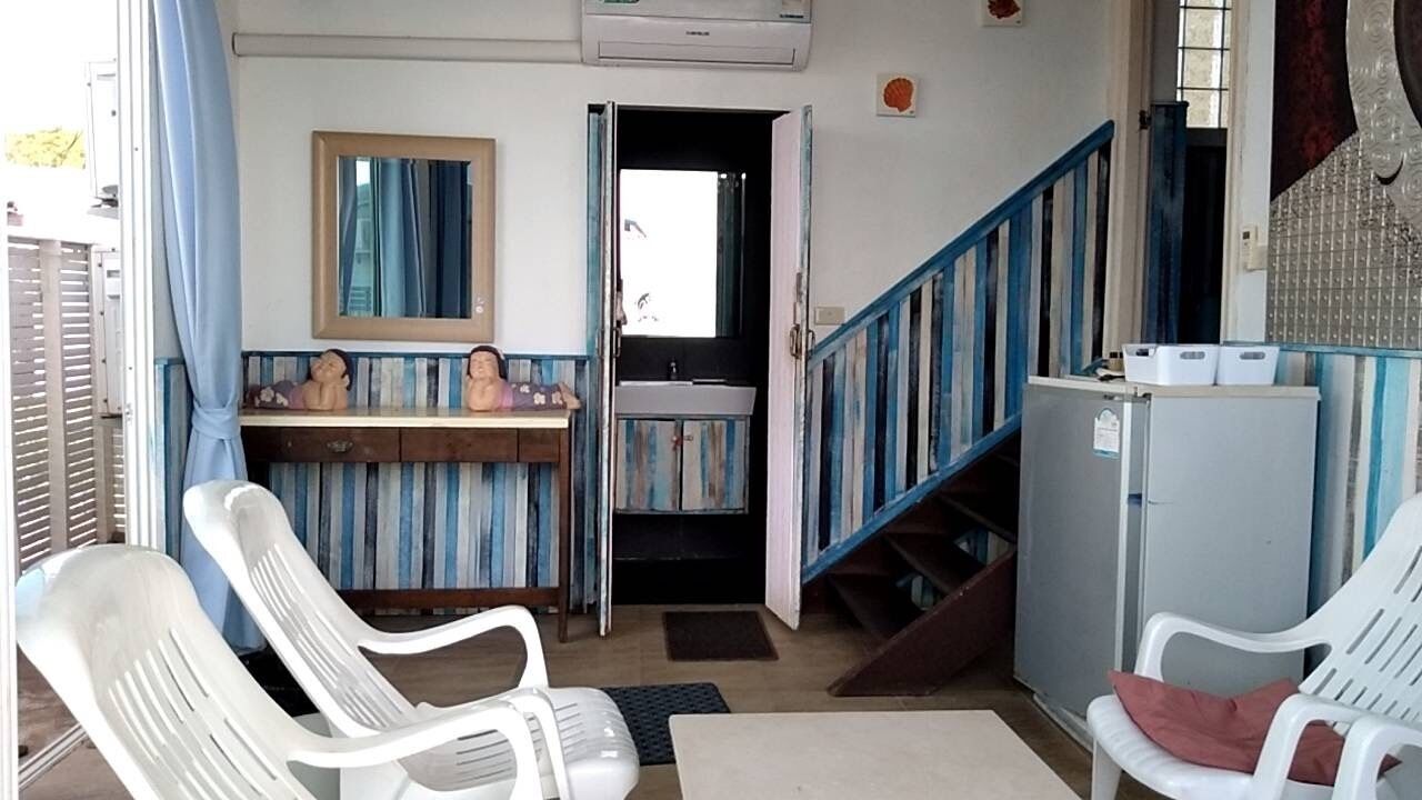 A compact living space with a kitchenette, a bathroom, and a staircase.