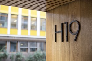 A wooden wall with the letters "H19" mounted on it. - Frogner House - Vika (Oslo)