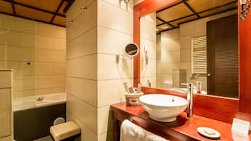 A modern bathroom with a bathtub, a sink, and a mirror.