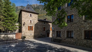 A stone building with a traditional design, featuring multiple windows and a central entrance.