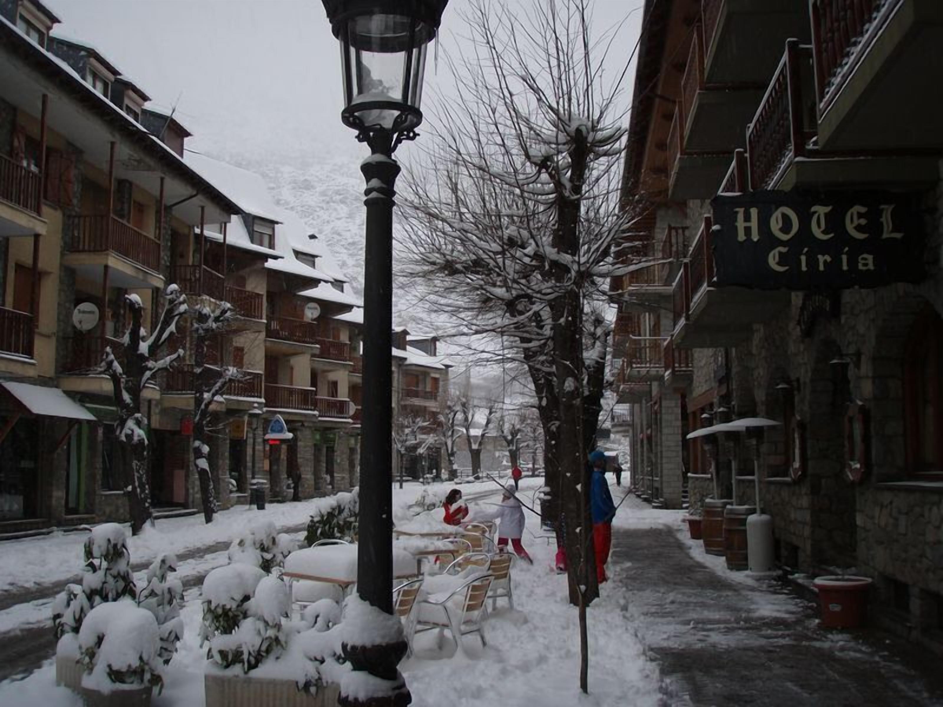 Une rue enneigée, avec un hôtel appelé « HÔTEL Ciria » sur le côté droit.