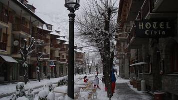 Una calle nevada con un hotel llamado "HOTEL Ciria" a la derecha.
