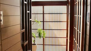 Un pasillo con paredes de madera, una escalera, una lámpara colgante y una planta en maceta.