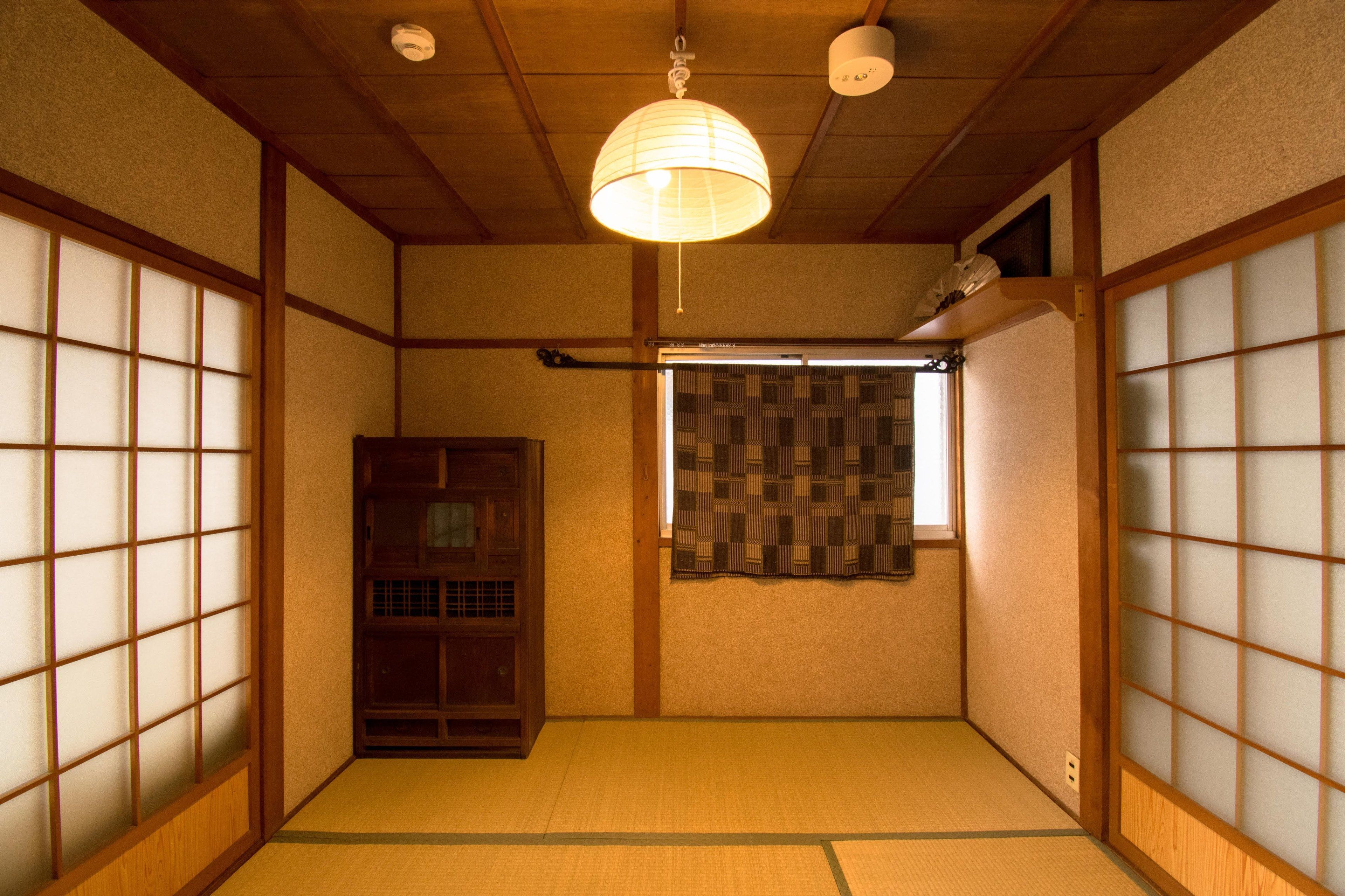Een traditionele Japanse kamer met tatami vloerbedekking, schuifdeuren en een houten kast.