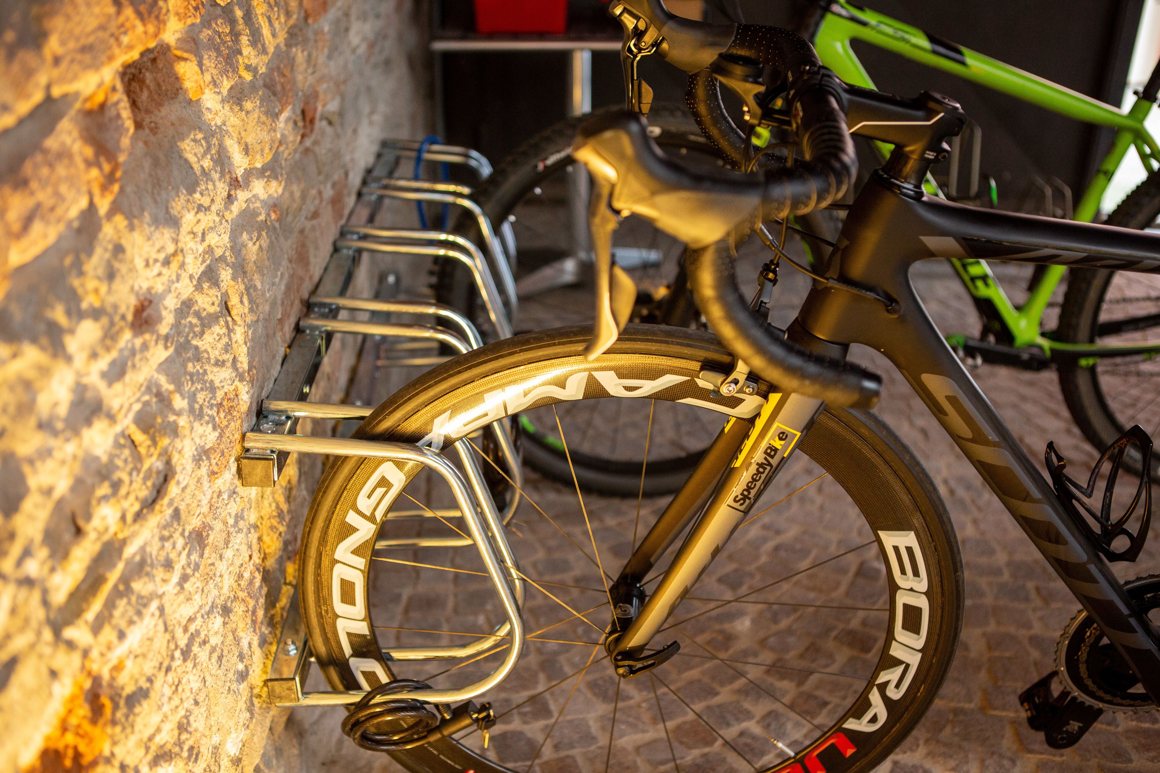 Una bicicletta con portapacchi anteriore e posteriore, appoggiata a un muro.