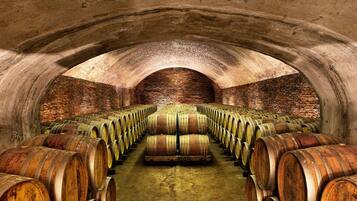 A wine cellar with rows of wooden barrels.
