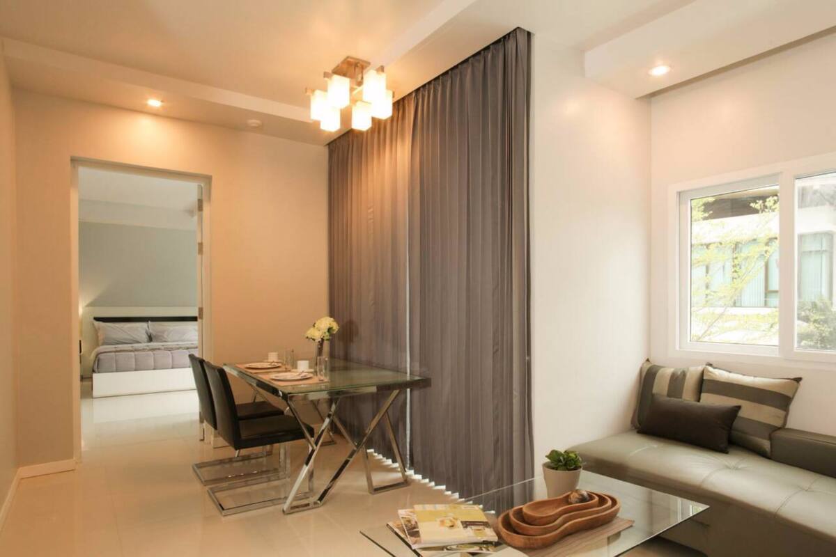 Una sala de estar moderna con una mesa de vidrio, un sofá y un amplio ventanal.