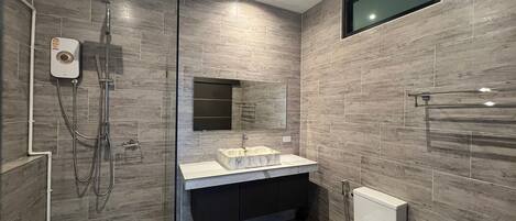 A modern bathroom with a glass-enclosed shower, a marble sink, a dark vanity, and a toilet.