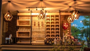 A bar area with shelves of glasses and bottles, a heart-shaped sign, and hanging lights. - Belong Jin The Dam Hotel & Resort (Ban Ta Khun)