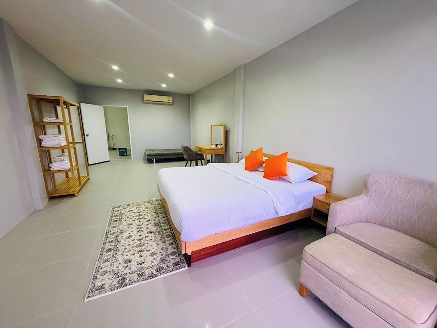 Une chambre d’hôtel moderne équipée d’un grand lit, d’un canapé, d’un bureau et d’une armoire.