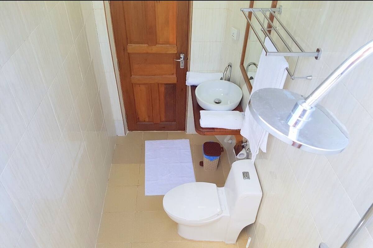 A small bathroom with a toilet, sink, and a mirror.