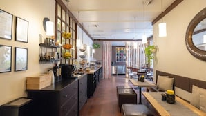 Una cocina moderna con una isla central, una zona de comedor con banco y vista hacia el comedor contiguo.
