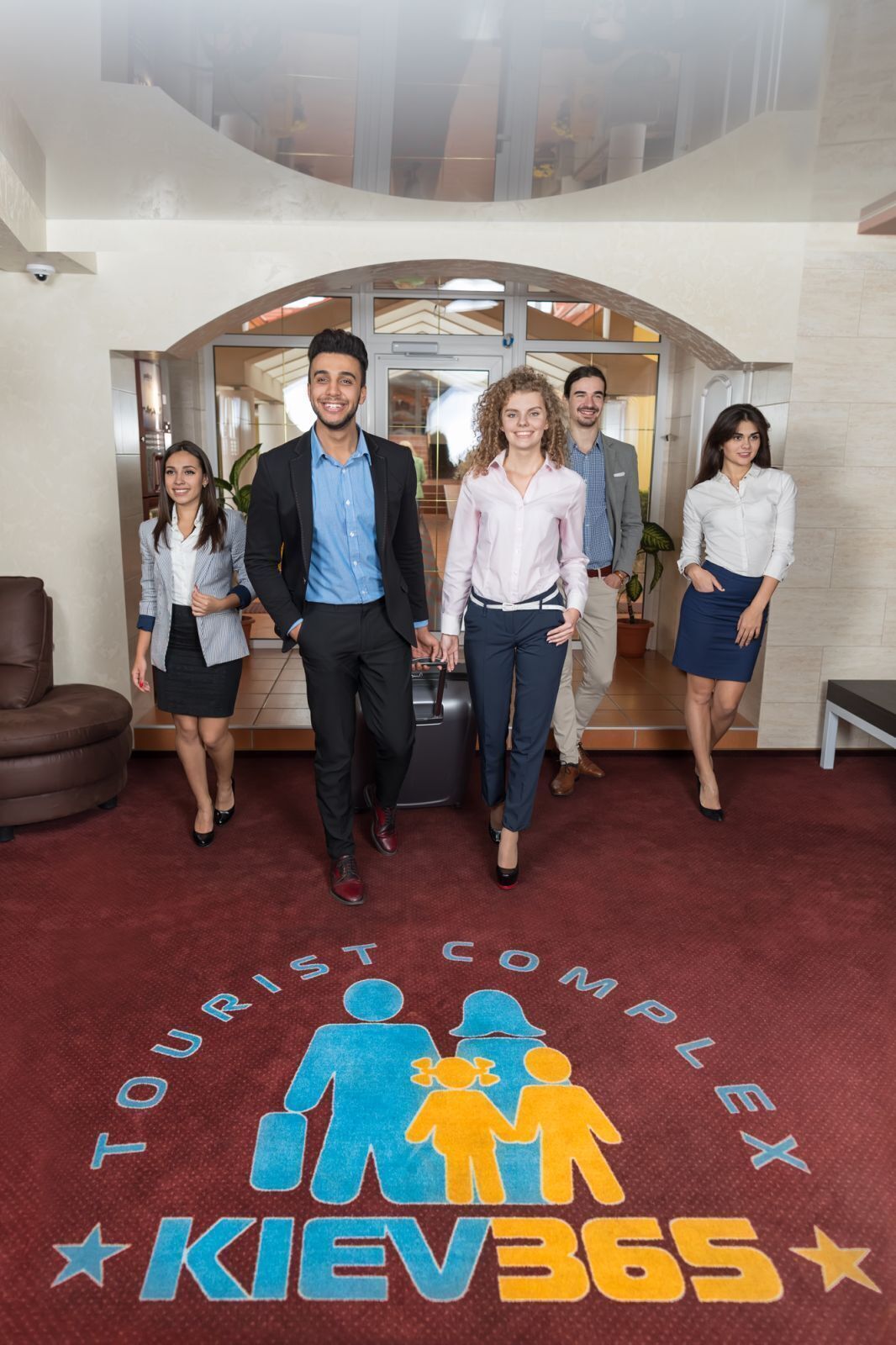 A group of people standing in a lobby with a red carpet and a sign that reads "TOURIST COMPLEX KIEV365".