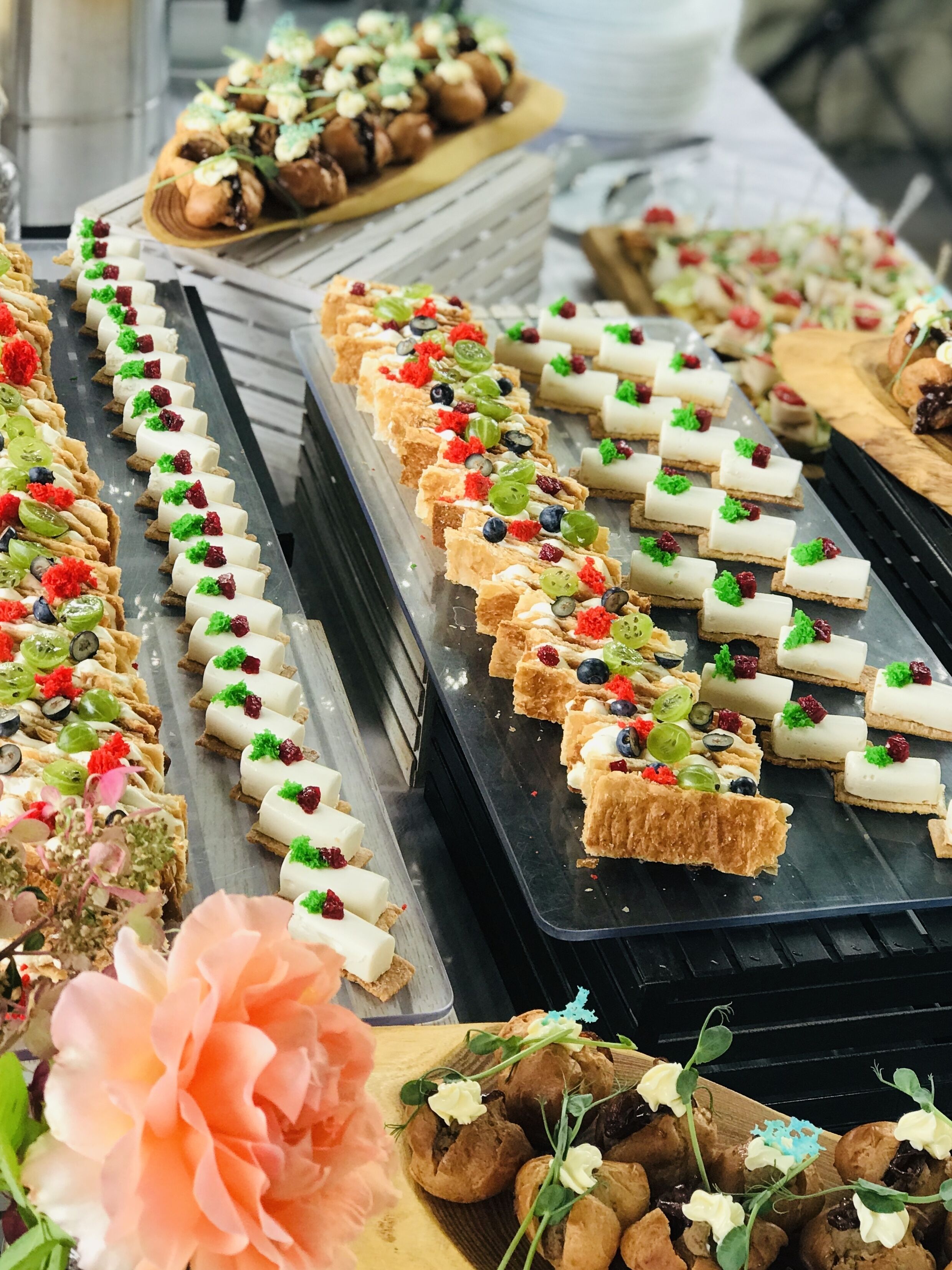 Un bufé con diversos postres y pasteles, que incluyen tartas y preparaciones con fruta, presentados en bandejas.
