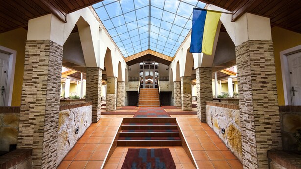 A spacious atrium with a high ceiling, tiled floor, and a central staircase leading to upper levels. - Kiev365 (Sofiivska Borschahivka)