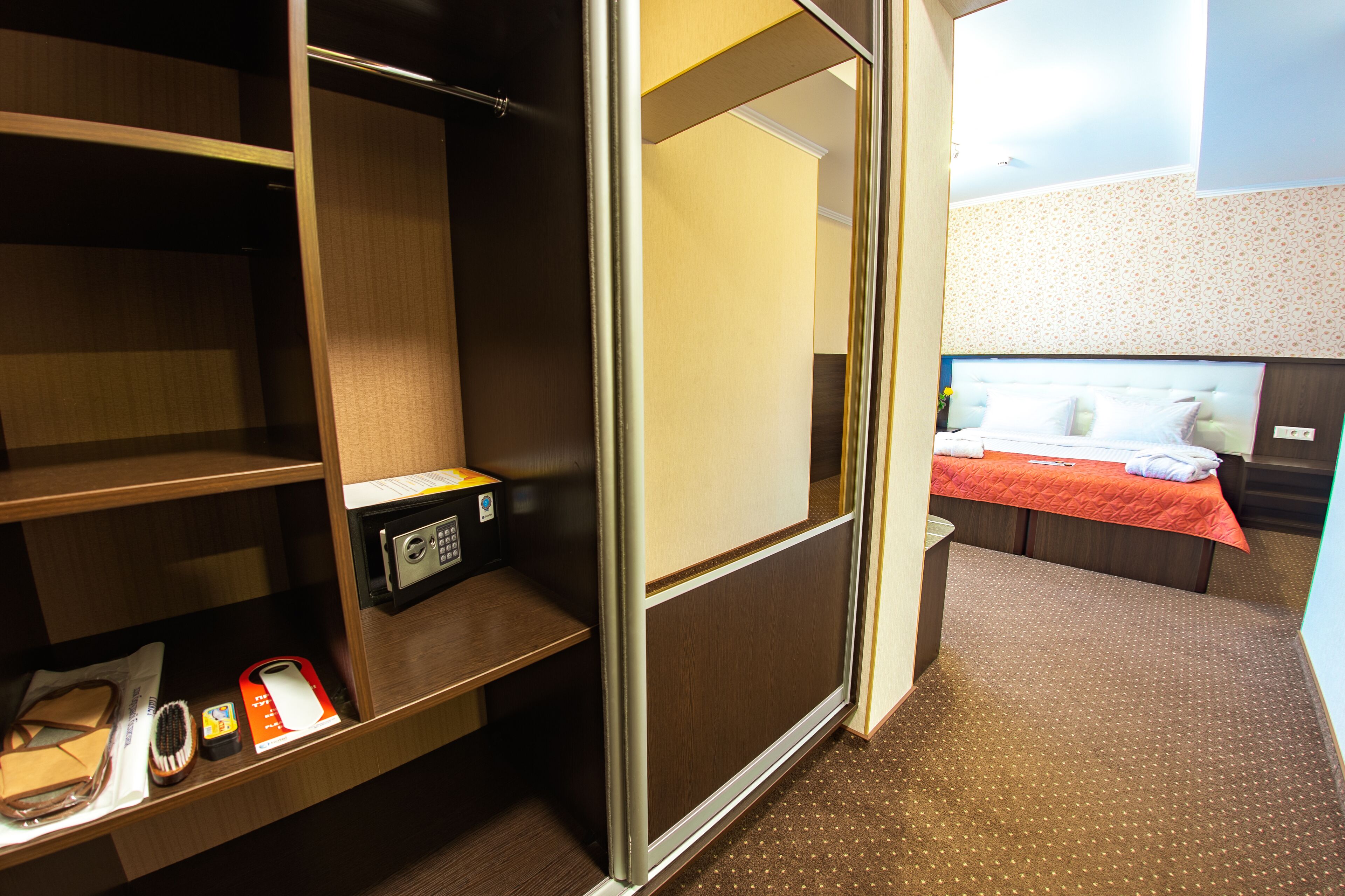 A hotel room with a bed, a desk with a computer, and a wardrobe.