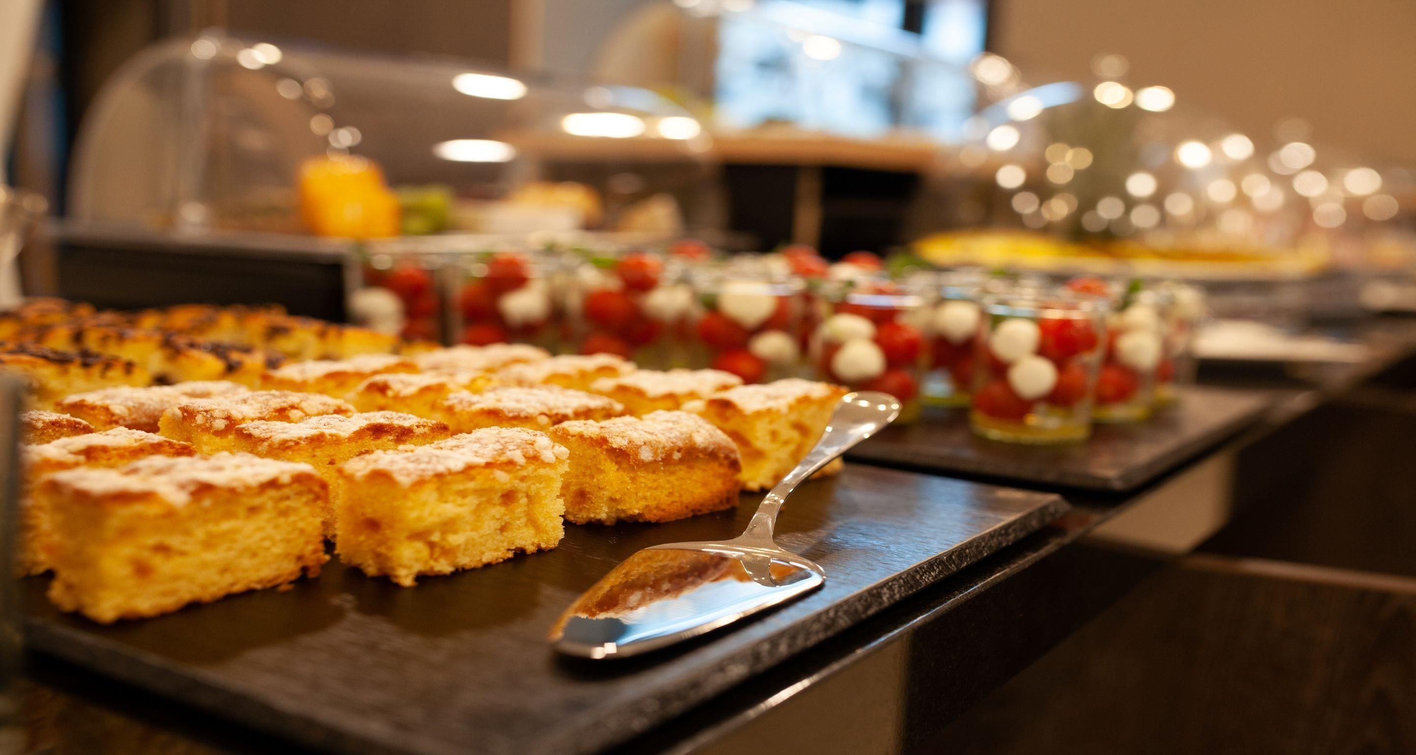 A buffet with various food items including pastries and fruit.
