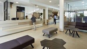 Un moderno área de recepción con mostrador, zona de estar y bar.