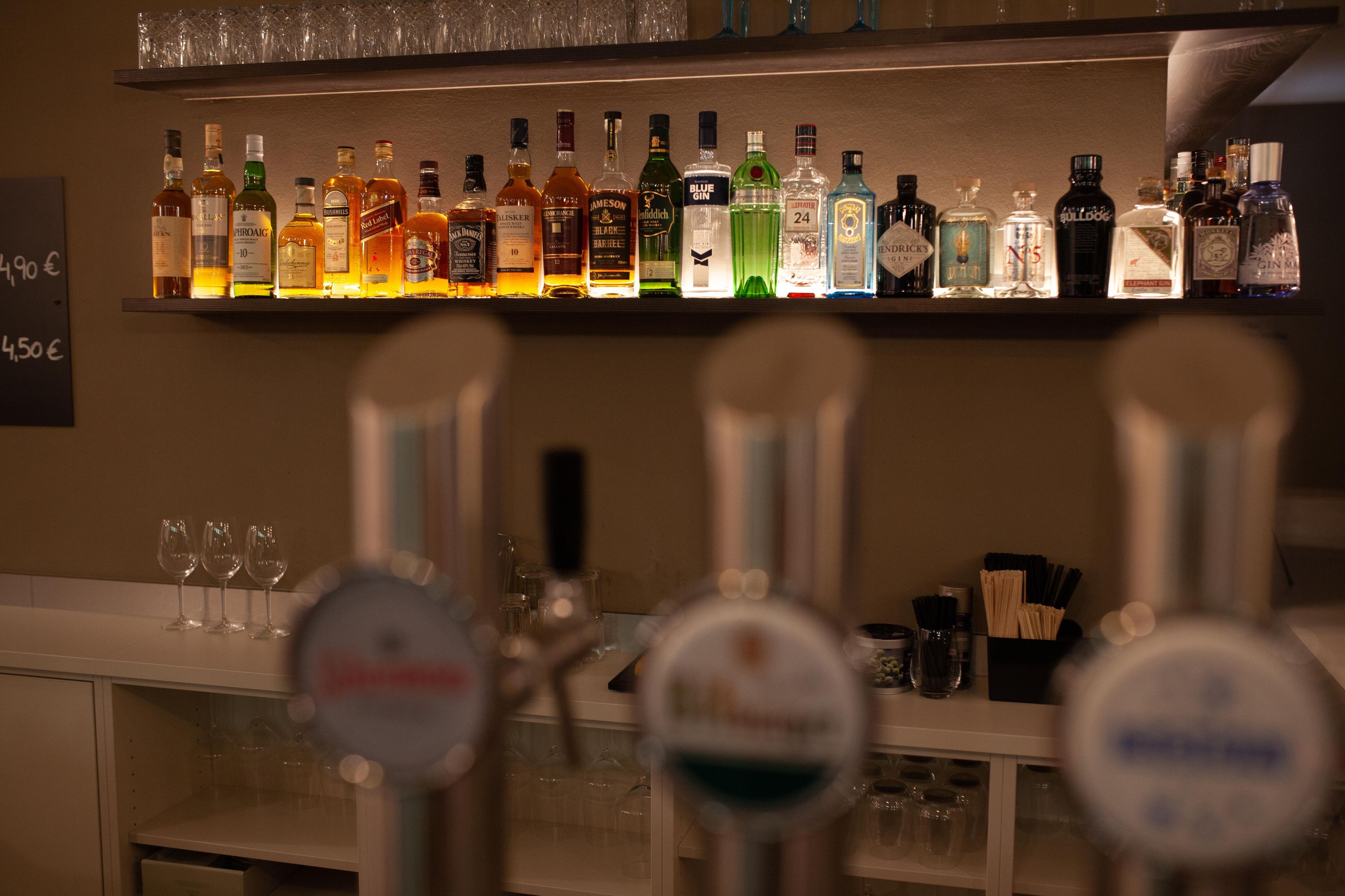 Eine Bar mit verschiedenen Spirituosenflaschen und Gläsern.