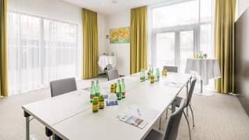 A conference room with a long table, chairs, and various items on the table including bottles and papers.