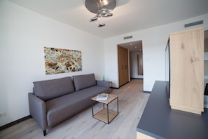 Ein modernes Wohnzimmer mit einem grauen Sofa, einem Couchtisch und einer Holzkommode.