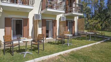 A residential building with balconies, outdoor seating, and a garden.