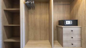 Un armario de madera con repisas abiertas, un microondas y un pequeño conjunto de cajones.