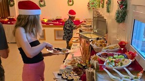 A buffet setup with various food items and a person serving. - Luau Beach Inn (Fulidhoo)