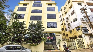 A multi-story hotel with a yellow facade, a visible entrance, and a staircase leading to the entrance. - FabHotel M Hotel Hitech City (Hyderabad)