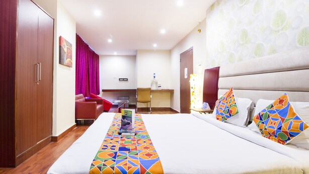 A hotel room with a bed, a desk, a chair, and a wardrobe. - FabHotel M Hotel Hitech City (Hyderabad)