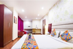 Une chambre d’hôtel avec un lit, un bureau, une chaise et une armoire.