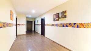 A hallway with wooden flooring, colorful wall tiles, and artwork. - FabHotel M Hotel Hitech City (Hyderabad)
