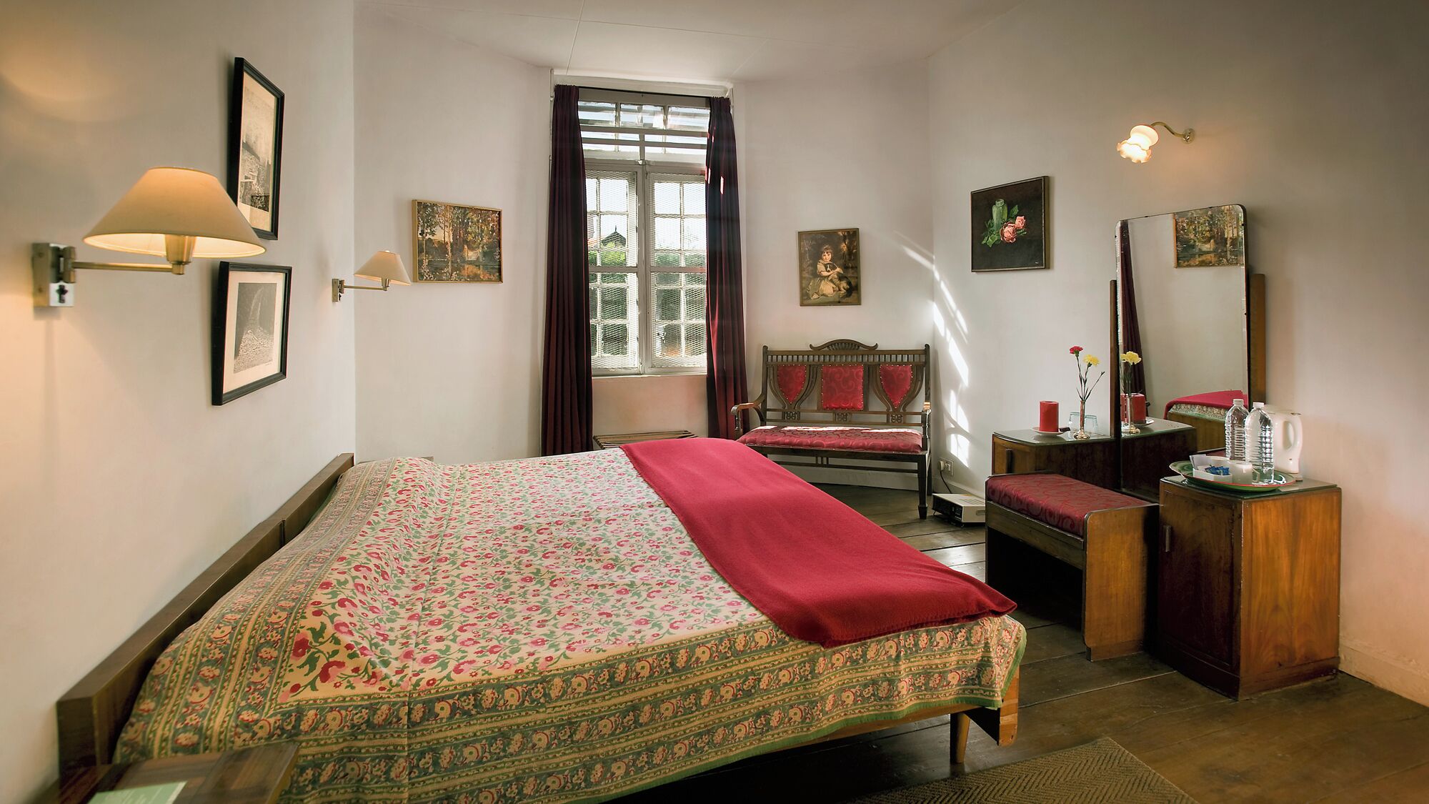 Un dormitorio con cama, escritorio, silla, ventana y espejo.
