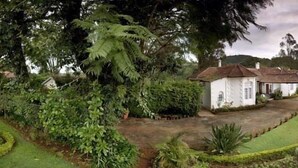 A rural house with a garden and a road nearby.