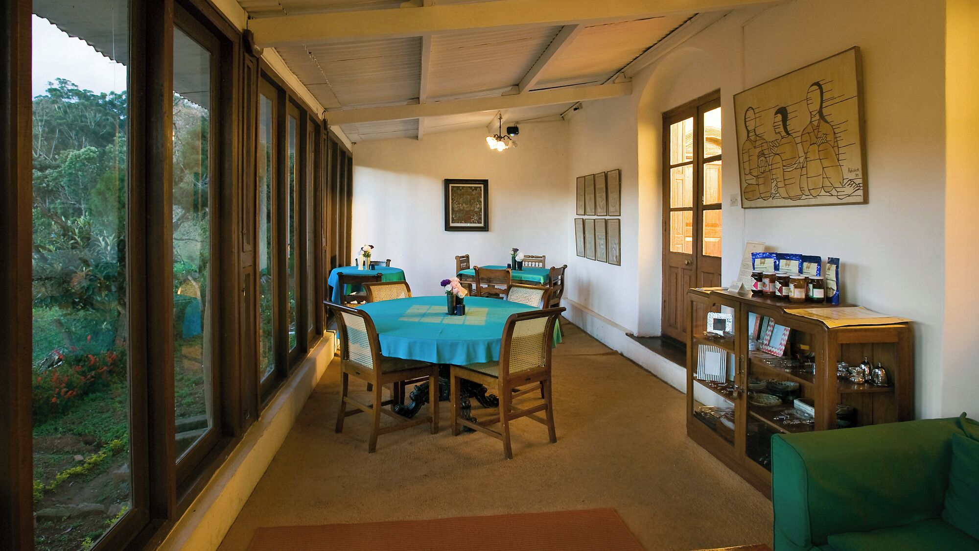 A dining area with a round table, chairs, and a bookshelf.