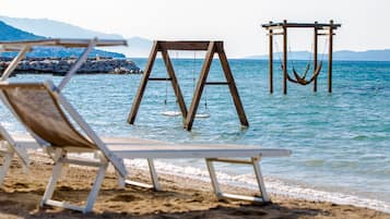 Pantai di sekitar, kursi berjemur, payung pantai, dan handuk pantai