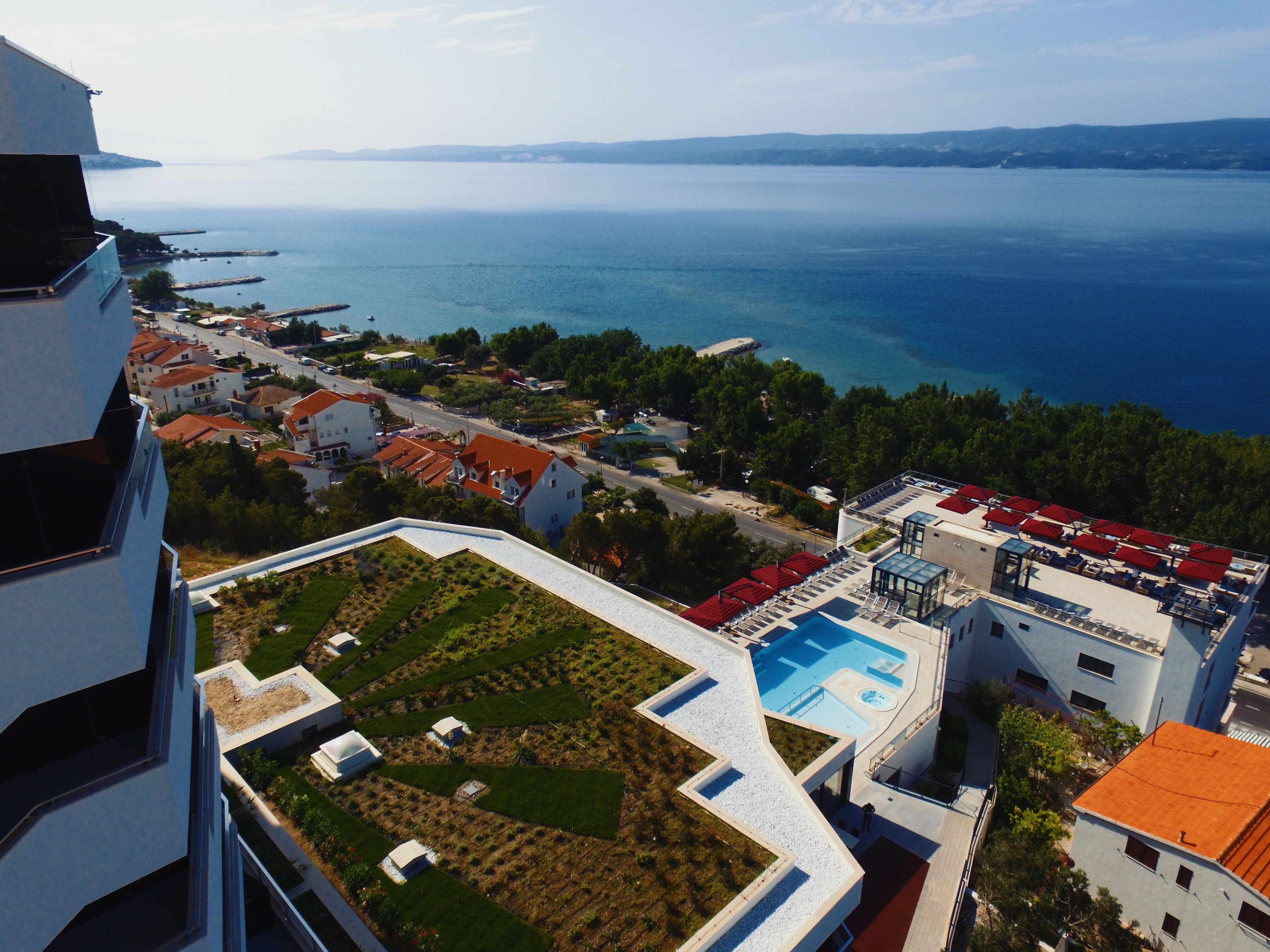 Un hôtel de grande hauteur doté d’une piscine sur le toit, de jardins en terrasses et offrant une vue sur la mer.