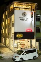 Un edificio con un cartello che indica 'Coconut Tree' e 'Kicks' al piano terra.