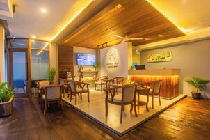 A reception area with wooden furniture, a TV, and a sign for Coconut Tree.
