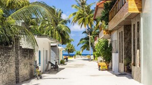 A narrow street lined with buildings, a bicycle, and a sign reading "Kaani Village". - Coconut Tree Hulhuvilla Beach (Hulhumalé)
