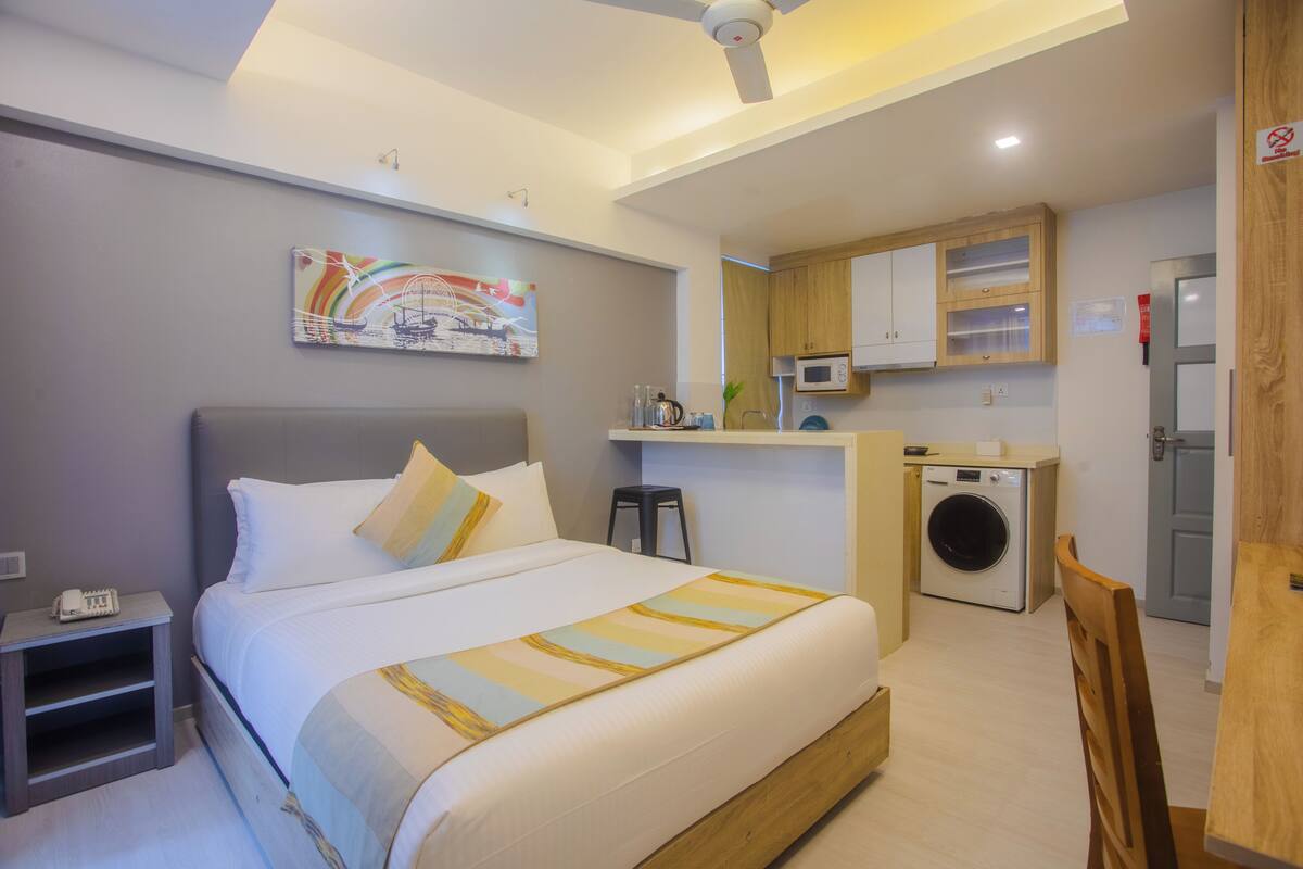 A bedroom with a bed, bedside table, and a ceiling fan.