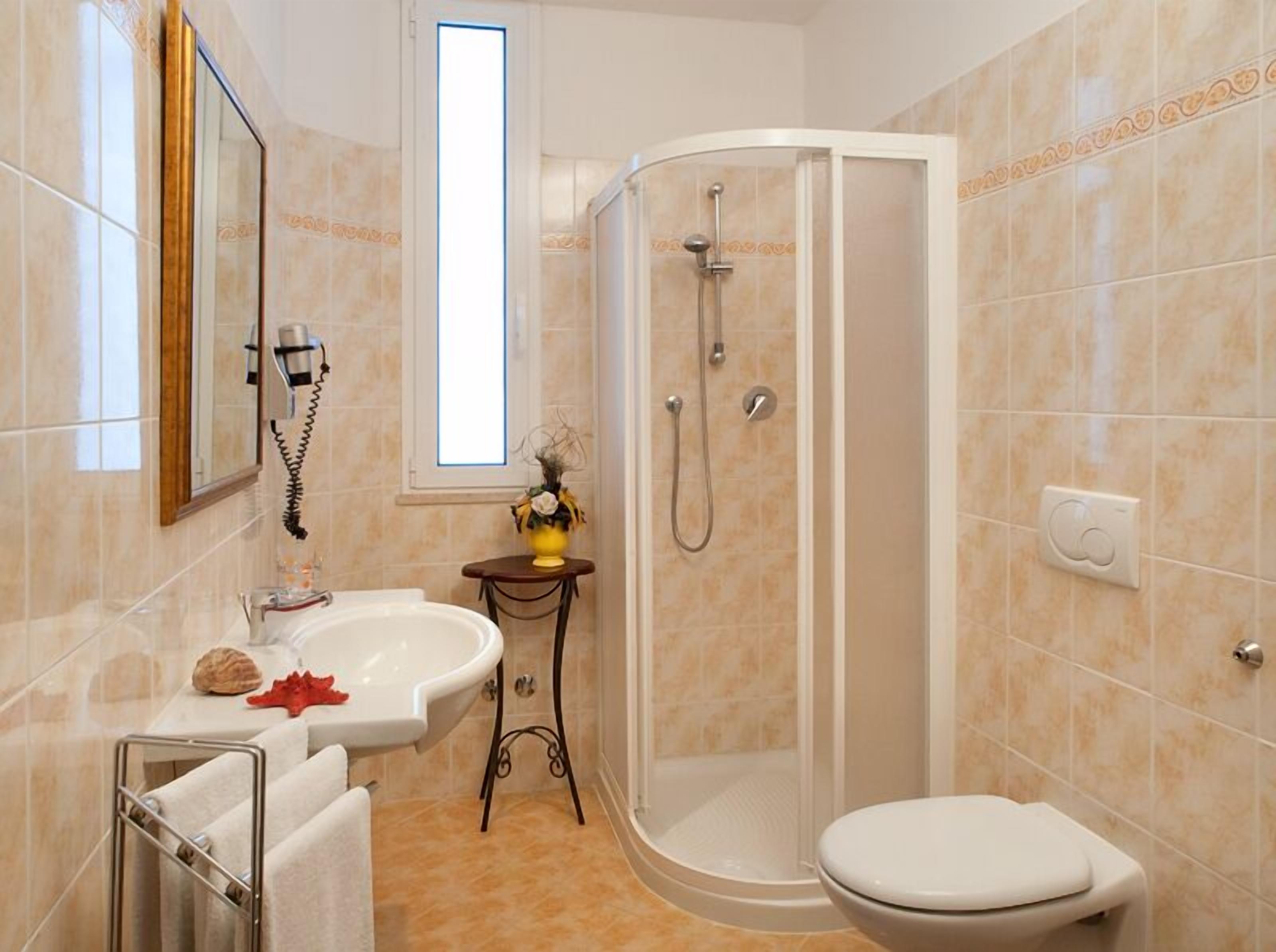 A bathroom with a white bathtub, a toilet, and a shower enclosure.