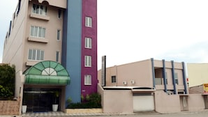 A multi-story hotel with a green entrance canopy, a purple and blue facade, and a flat roof. - Barao Center Hotel (Santarém)
